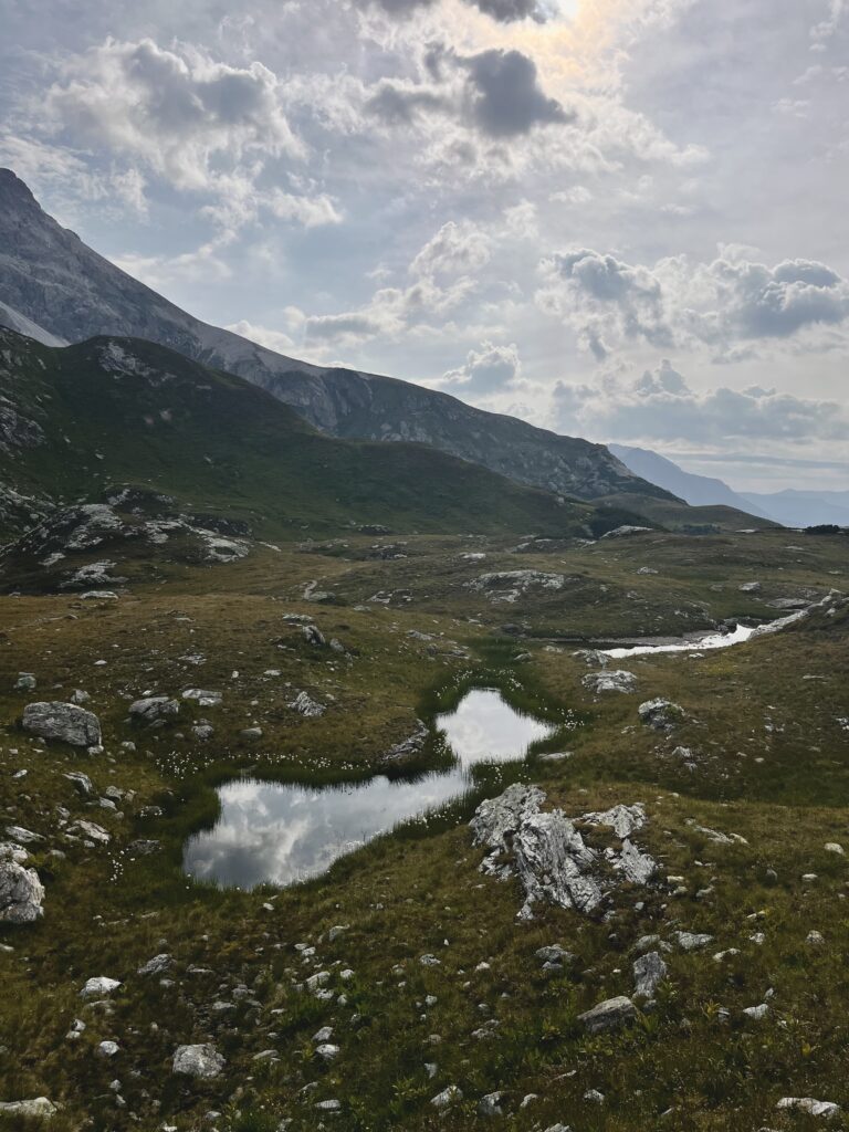 Tiny puddle in the mountains, clouds